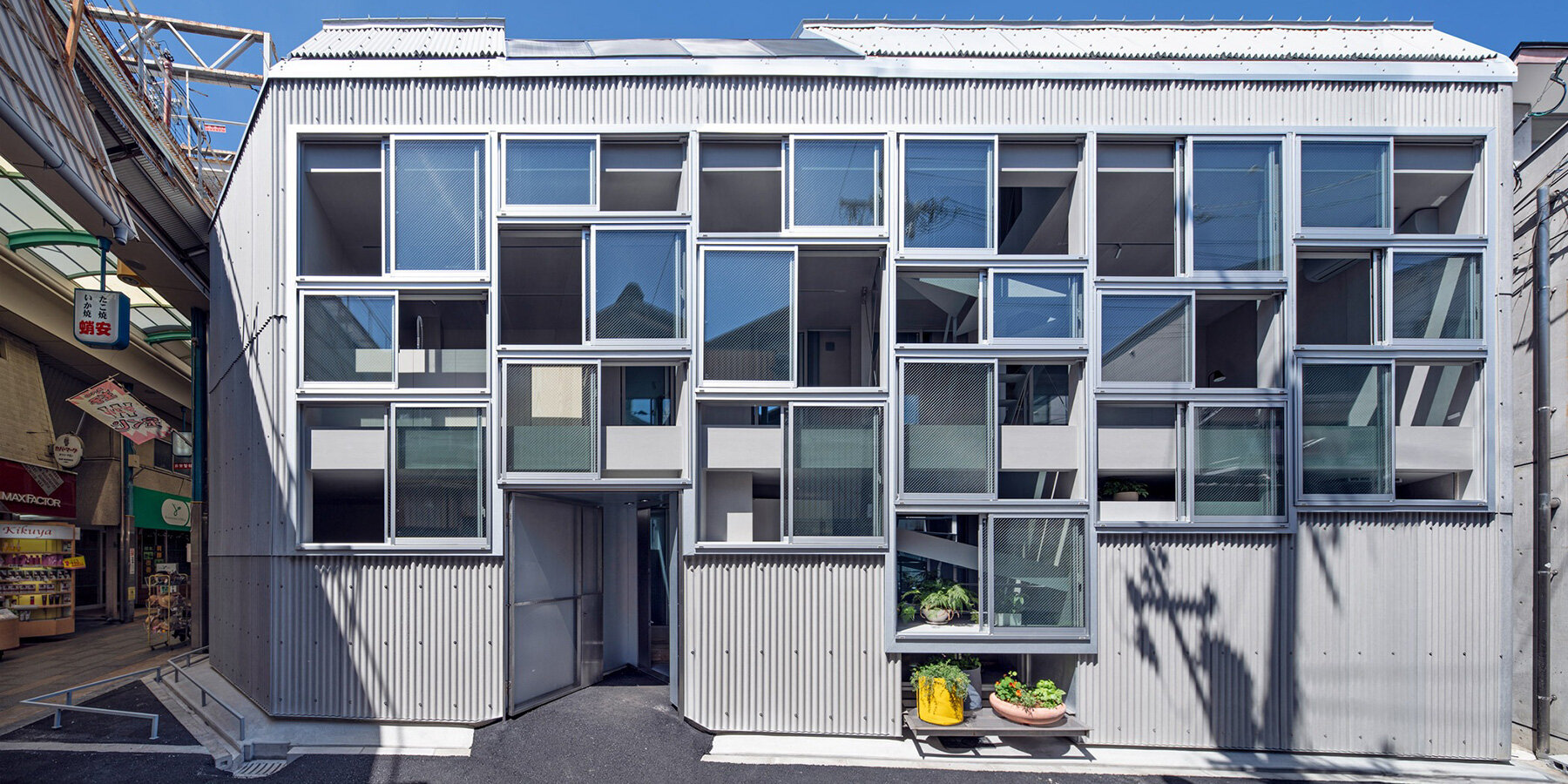 a facade composed of stacked aluminum-framed openings, all images by Keijiro Yamada
